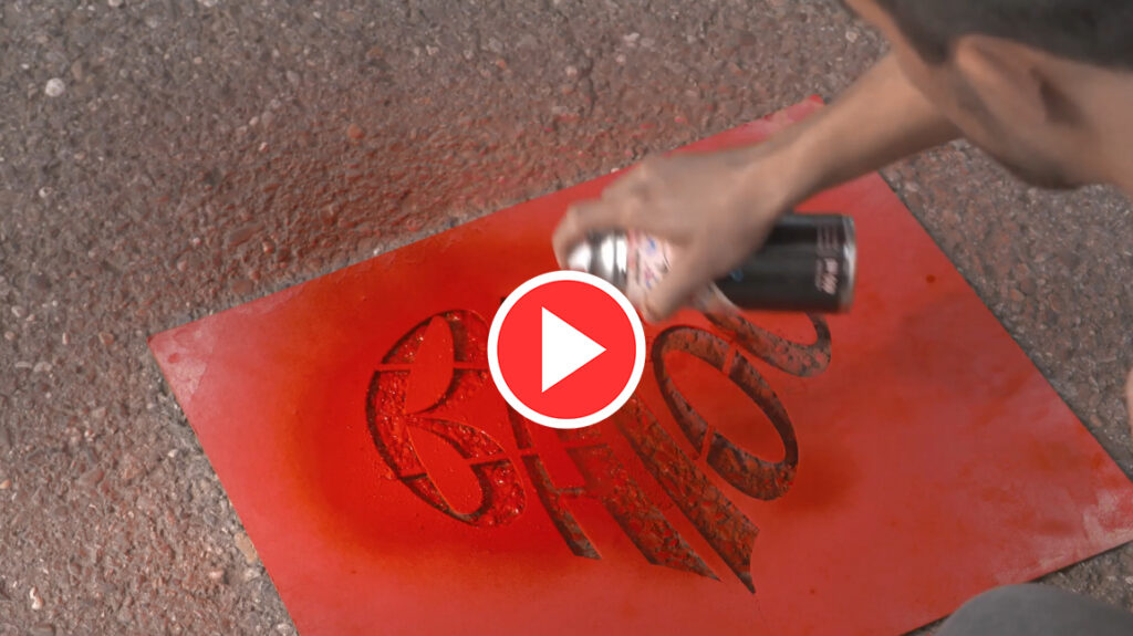 Hand sprayt rotes BAFÖG Logo auf Boden.