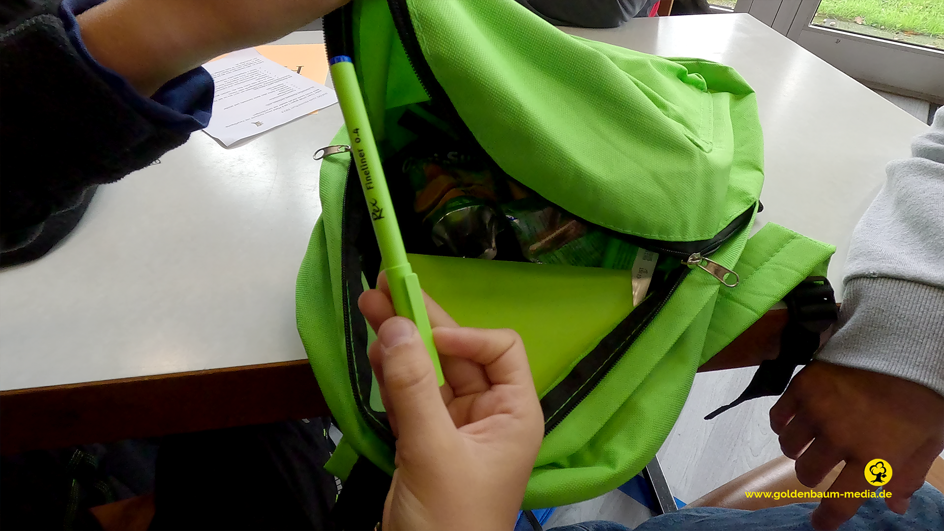 Grüner Rucksack mit Stift und Smnnacks für den hoemrun