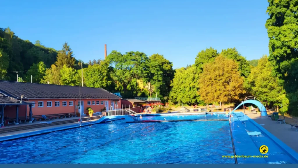 Schwimmbecken des nagoldfreibads Pforzheim mit Sanitär und Umkleidebreich im hintergrund